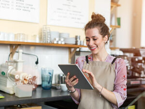 female business owner looking at tablet device | Honor Credit Union