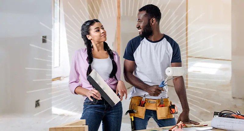 man and woman looking at each other while painting a room in a house