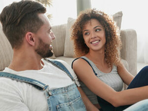 man and woman sitting on the floor in a living room by a couch | Honor Credit Union