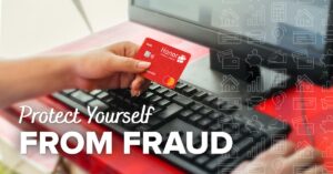person holding an honor debit card next to a computer | Honor Credit Union