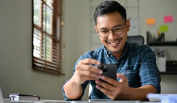 man smiling and looking at his phone