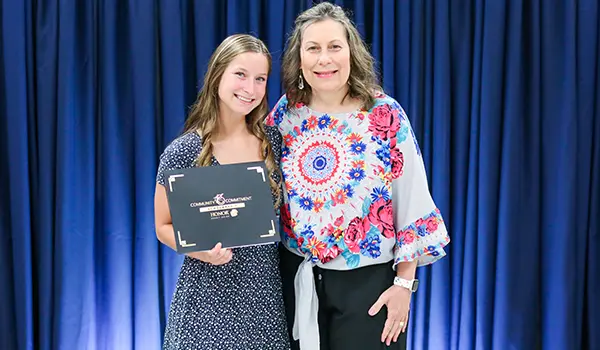 A 2023 scholarship winner stands with an Honor team member