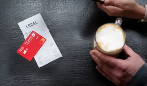cup of coffee resting on a table next to a receipt and an honor benefits checking debit card | Honor Credit Union