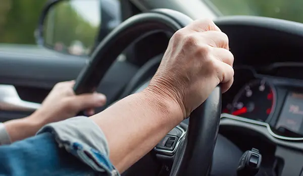 hands on a vehicle steering wheel