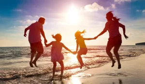 family jumping near the water at a beach | Honor Credit Union