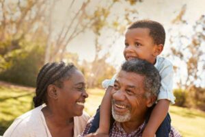 man with a grandson sitting on his shoulders and a woman standing next to him | Honor Credit Union
