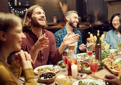 people sitting around a table eating and having fun