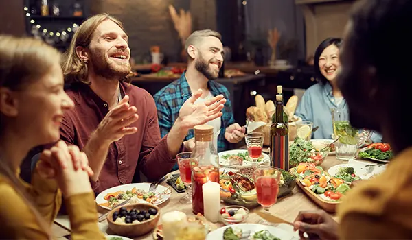 people sitting around a table eating and having fun