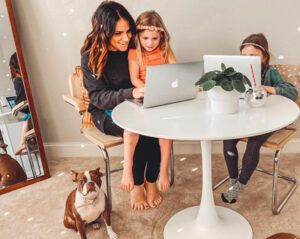 woman sitting with two children at a small table looking at a laptop | Honor Credit Union