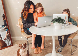 woman sitting with two children at a small table looking at a laptop | Honor Credit Union