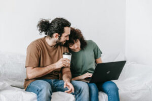 man and woman sitting next to each other looking at a laptop | Honor Credit Union