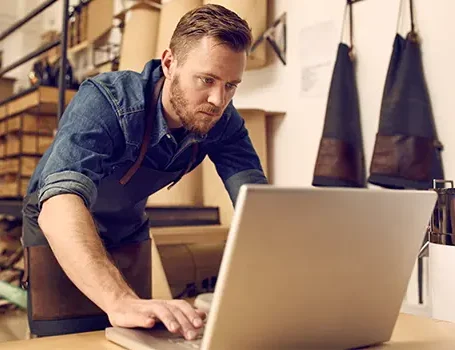 business owner looking at a laptop in his workshop