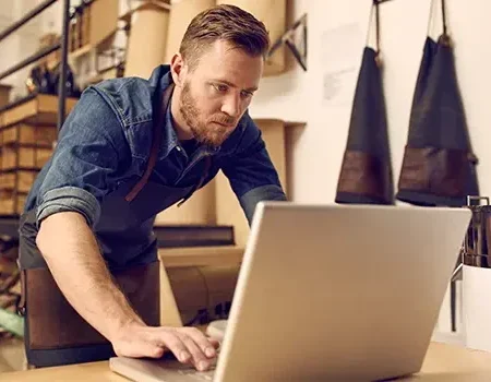 business owner looking at a laptop in his workshop
