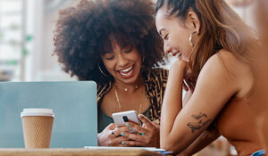 friends smiling at a cafe referring a friend to Honor with refer a friend | Honor Credit Union