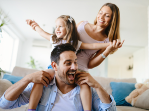dad with young female child on his shoulders with her arms being held by her mother | Honor Credit Union