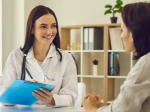 doctor writing on a clipboard talking with a patient | Honor Credit Union