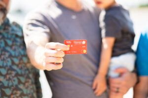 man holding a child with an Honor debit card in focus | Honor Credit Union