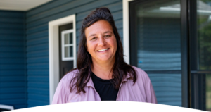 Honor member Julie, smiling in front of her Honor financed home | Honor Credit Union
