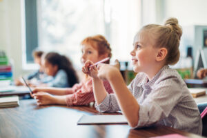 girls sitting in a classroom listening to their teacher | Honor Credit Union