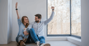 a couple holding hands with one hand in the air excited that they paid off their mortgage | Honor Credit Union