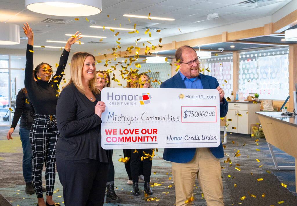 CEO Scott McFarland presenting a check of 0,000.00 to Michigan Communities