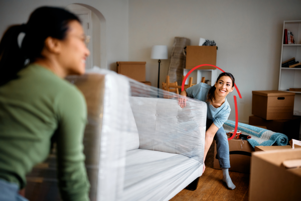Ladies moving a couch into a new house