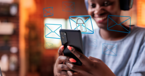 Close-up of a person holding a smartphone with floating blue email icons and a padlock, representing secure messaging or email security. | Honor Credit Union