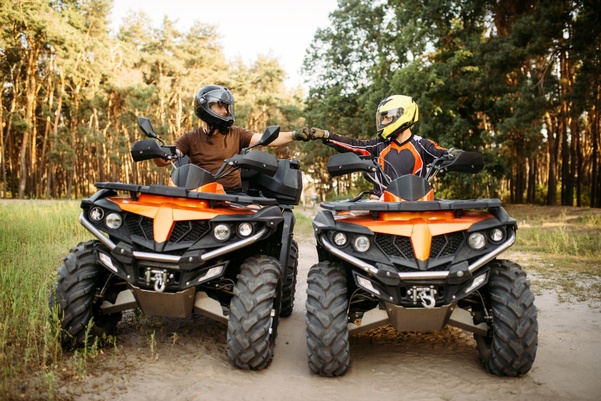 two people on four wheelers