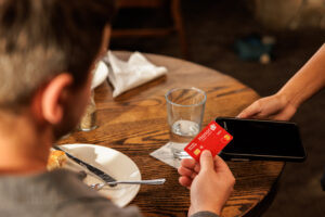 man paying a dining bill with his Honor credit card tap and pay | Honor Credit Union