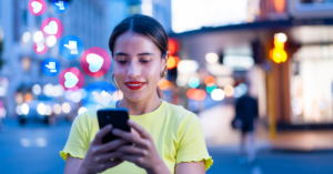 women on social media on cell phone with like icons around her | Honor Credit Union