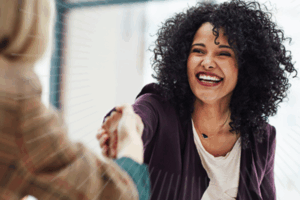 women smiling and shaking hands | Honor Credit Union