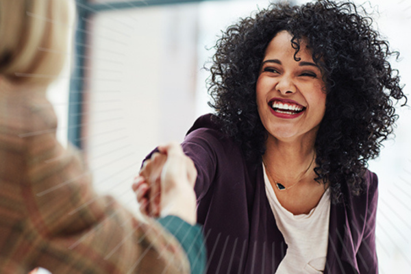 women smiling and shaking hands