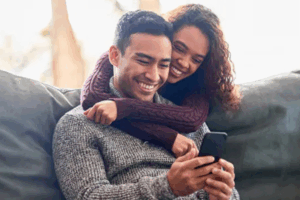 couple hugging looking at a cell phone | Honor Credit Union