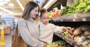 mother grocery shopping with her young daughter