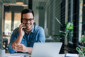 Man on the phone looking at his laptop | Honor Credit Union