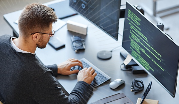 man on computer looking at code