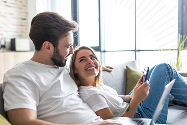 Couple on the couch looking at a cell phone