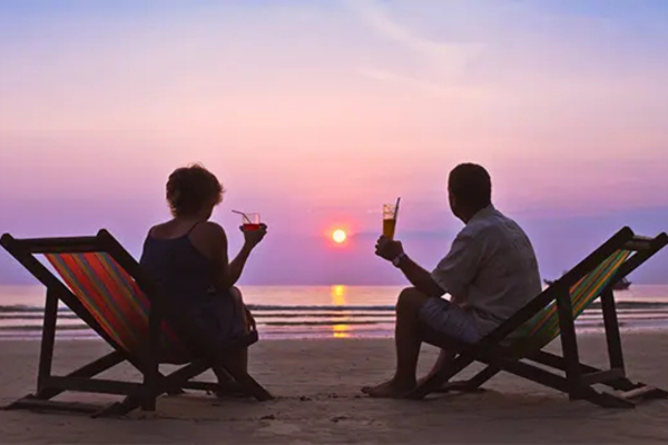 couple in chairs on the beach watching the sunset