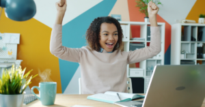 women looking at computer celebrating being out of debt | Honor Credit Union