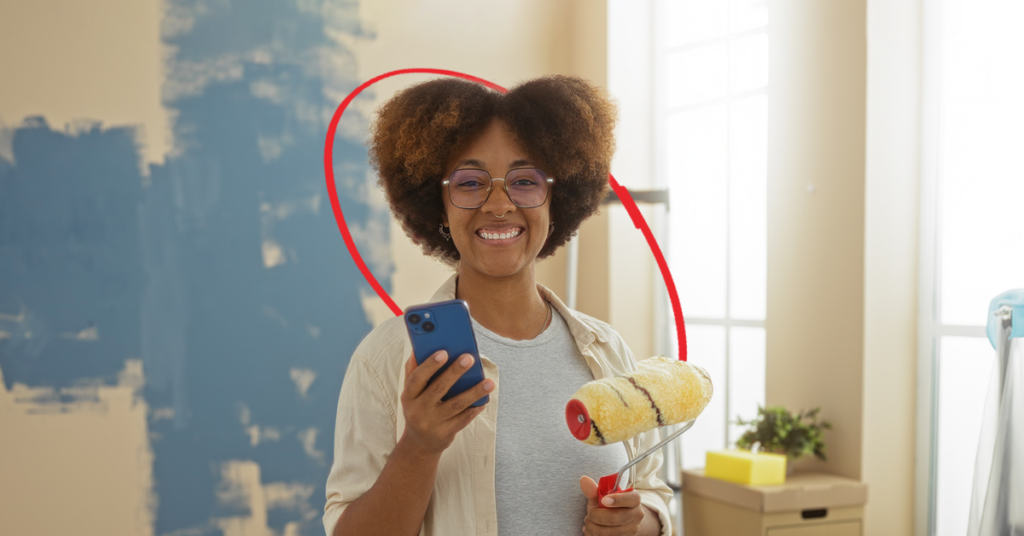 women holding a cell phone and a paint roller | Honor Credit Union