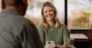 Two people talking at a café table, having a financial planning conversation. | Honor Credit Union