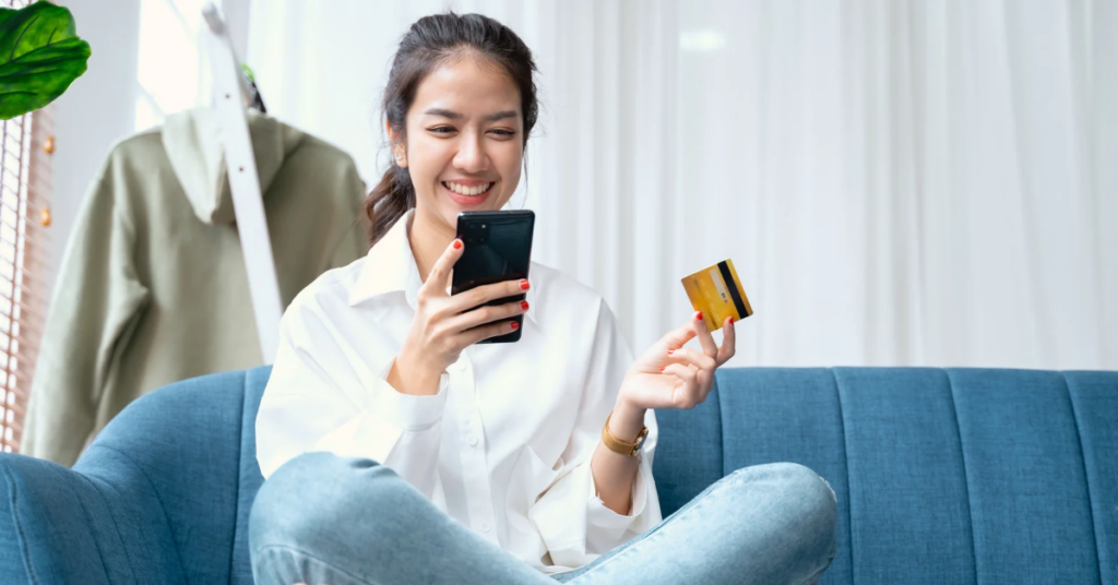women holding phone and credit card | Honor Credit Union