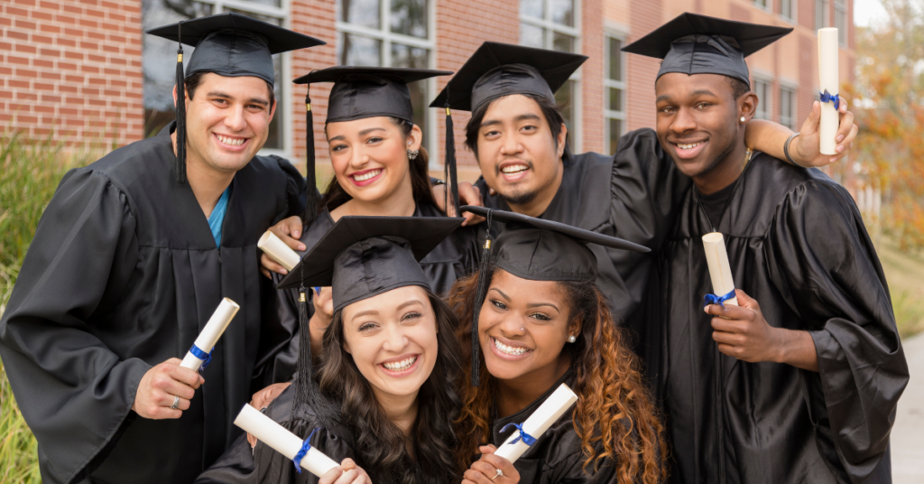 College Graduates posing in their hats and gowns with their diplomas