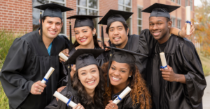 College Graduates posing in their hats and gowns with their diplomas | Honor Credit Union