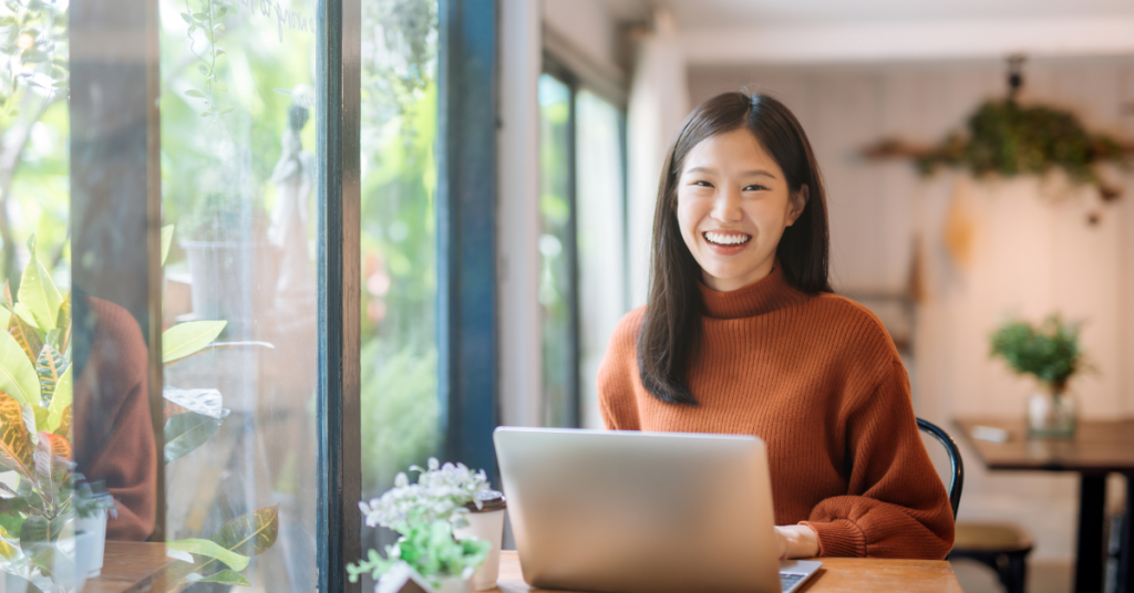 young women on laptop smiling | Honor Credit Union