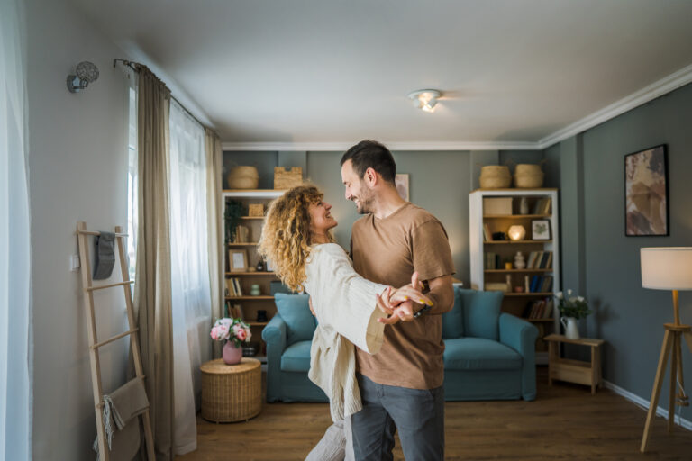 Happy husband and wife dance at home