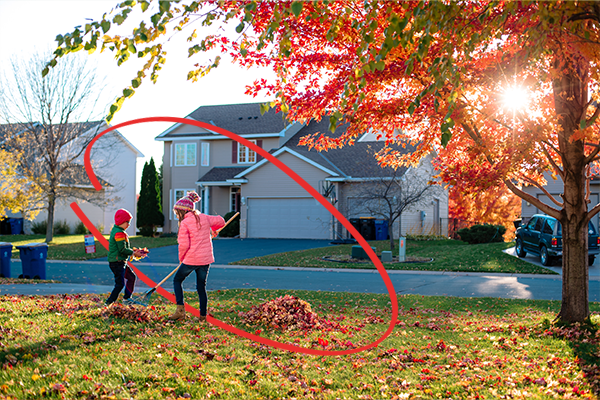 Family raking leaves in front of their home