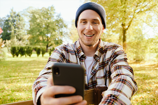 man looking at his cell phone outside | Honor Credit Union | Honor Credit Union