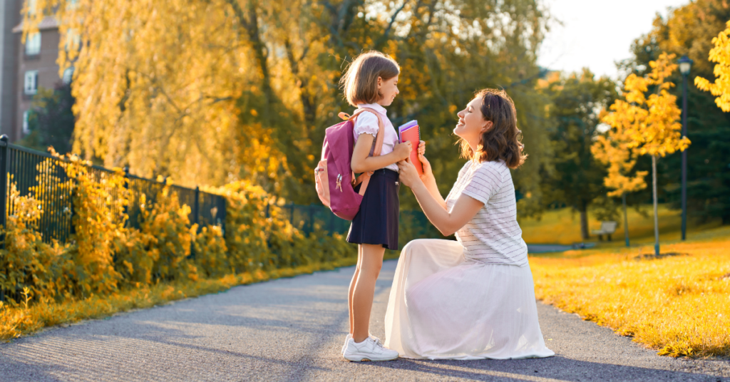 mother kneeling in front of young daughter with her backpack | Honor Credit Union