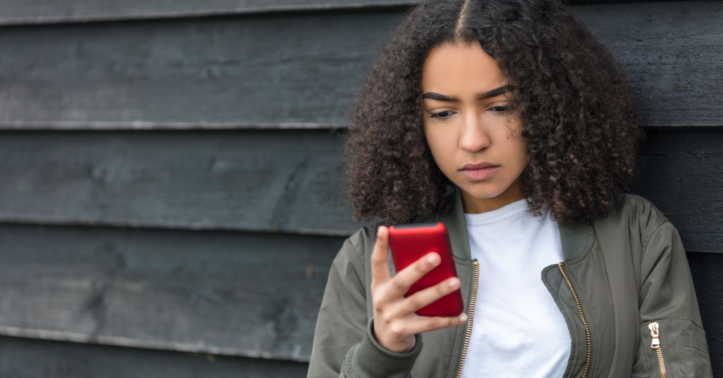 young women looking concerned at her cell phone | Honor Credit Union